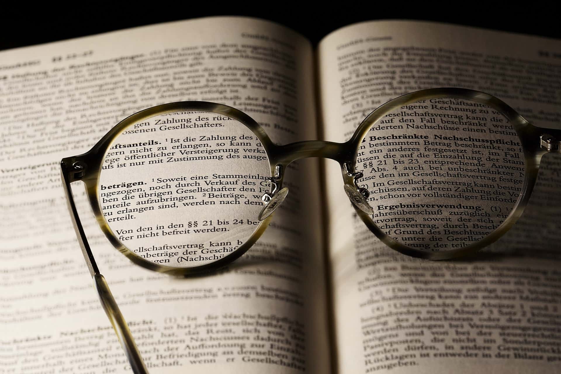 Okulary leżą na książce i pozwalają zauważyć tekst, zupełnie jak algorytm Boyera-Moore-a
